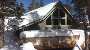 A Cabin in the Middle of the Woods Covered in Snow