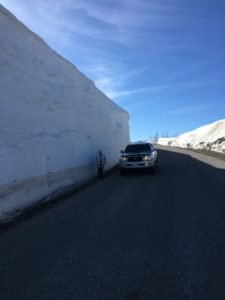 a car and a man on the road with snow around