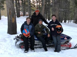 four men posing After riding snowmobiles