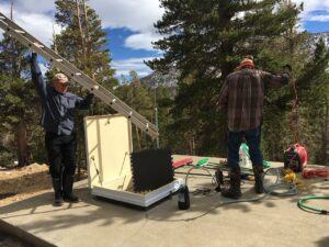 Two Men Repairing a Water System With a Ladder