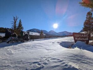 A Snow Covered Plain With a Board in Wood