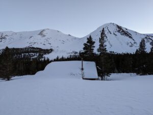 view of snow covered hut and mountains