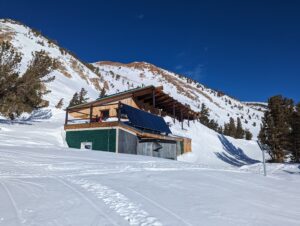 view of a hut surrounded by trees and snow