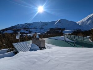 view of a house roof and sun above it