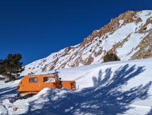 a yellow color truck stuck into the snow