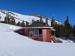 a hut with snow and trees around it