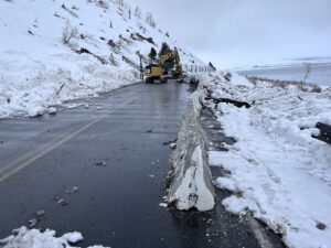 view of an excavator at the road covered with snow