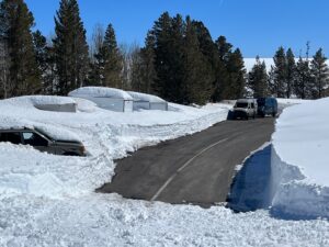 a parking lot and cars with snow around