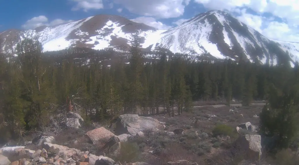 a view of partially snow covered mountains