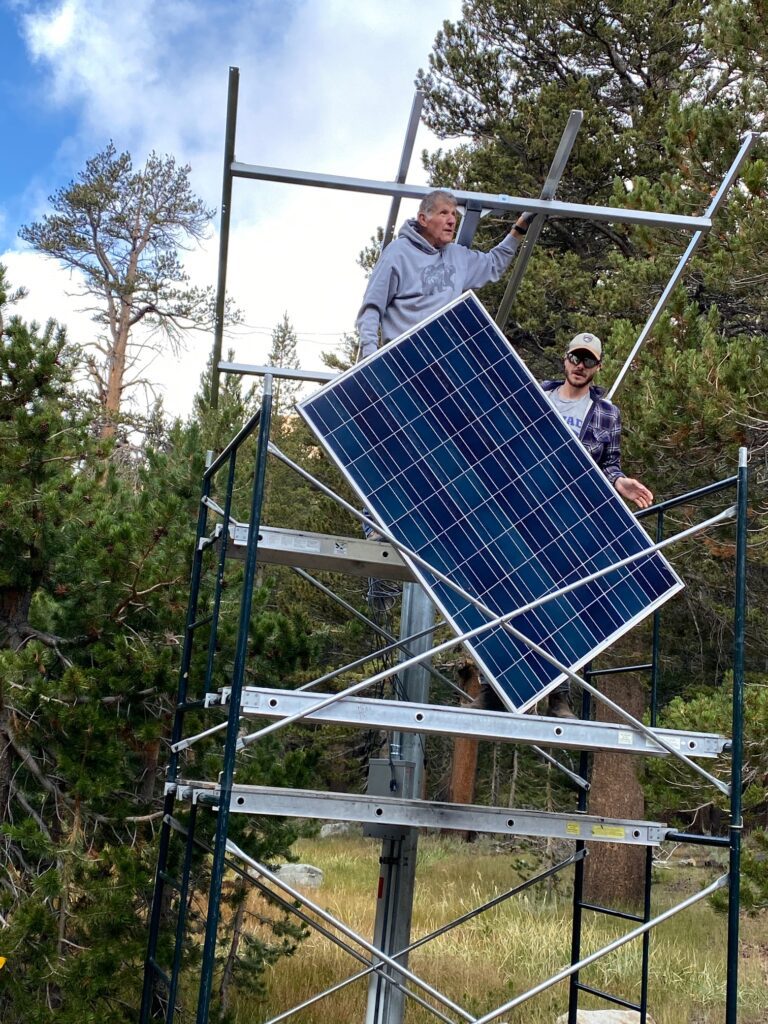 people removing solar panels from rack