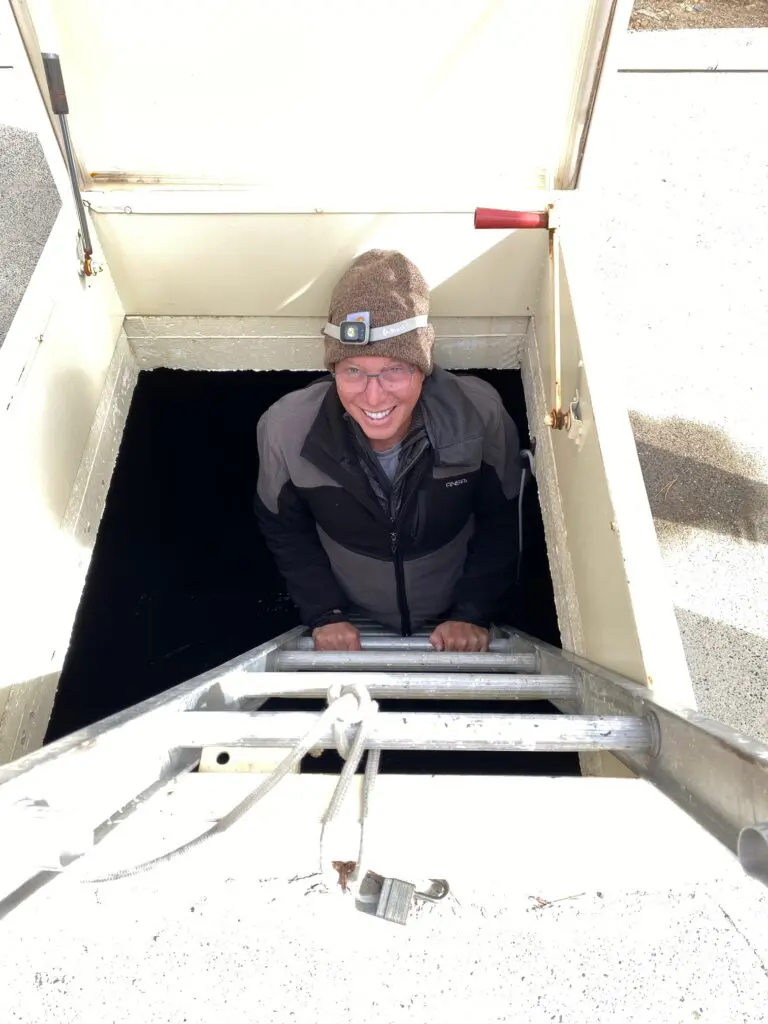 man climbs ladder out of low tank