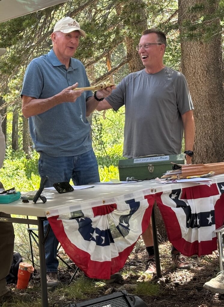 Ross receives the golden wrench from Chris